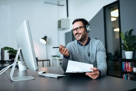 Handsome smiling man working at help desk.