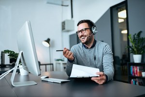 Handsome smiling man working at help desk.